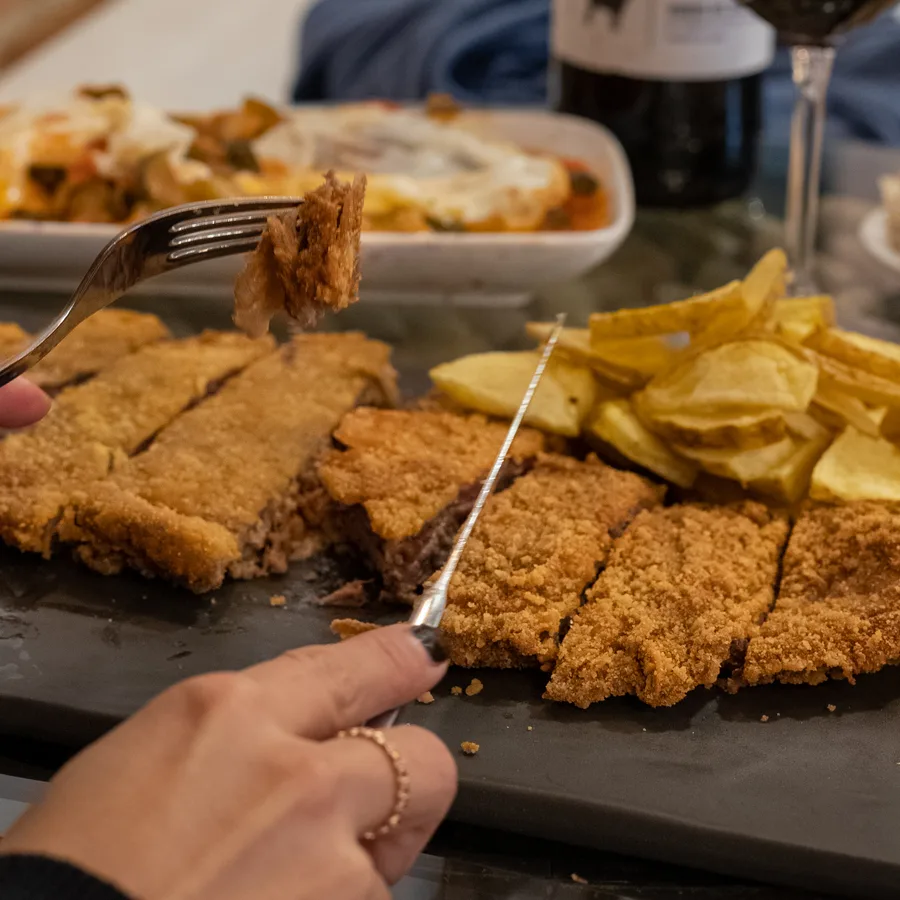 Cachopo El Corcho recién cortado con patatas